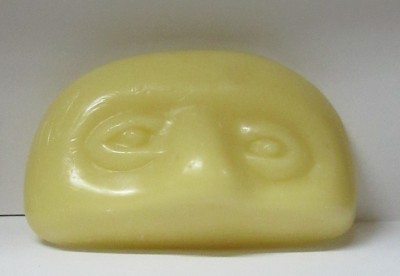 Sabonete amarelo com relevo de rosto humano
