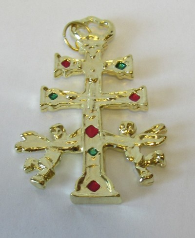 Pingente dourado cruz com pedras vermelhas e verdes sobre fundo branco