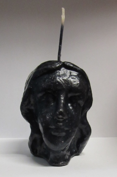 Vela preta em forma de cabeça feminina com pavio