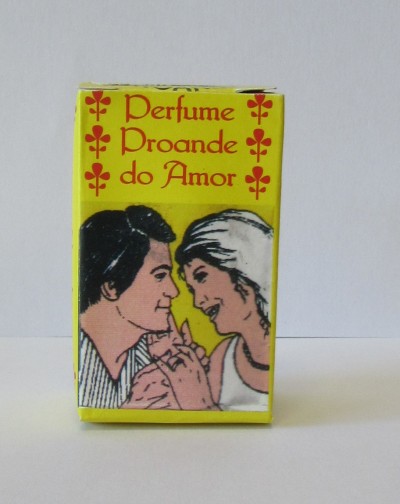 Caixa de perfume amarelo com texto vermelho e ilustração carinhosa de casal