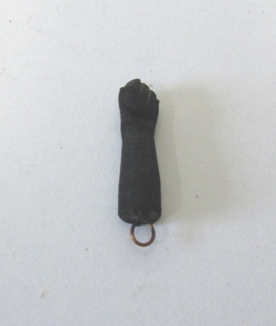 Amuleto em forma de braço fechado preto com anel metálico em fundo branco