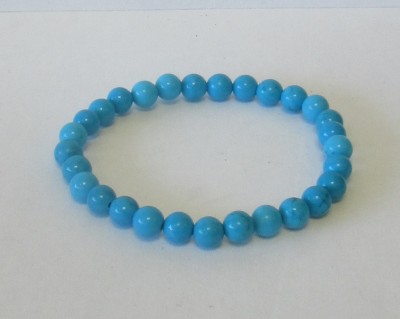 Pulseira de contas azuis redondas sobre fundo branco