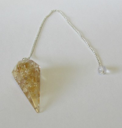 Pêndulo de cristal castanho pendurado numa corrente prateada com conta translúcida