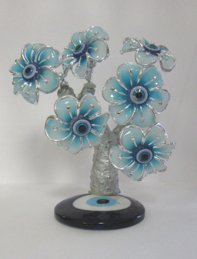 Escultura de árvore com flores azuis e base preta com padrão circular