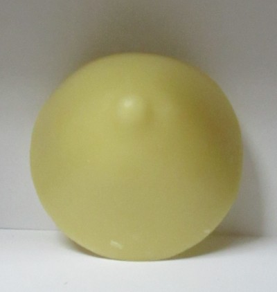 Disco amarelo redondo com relevo central em parede branca.