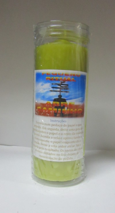 Vela verde em recipiente de vidro com etiqueta e instruções em português.