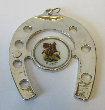 Amuleto em formato de ferradura prateada com imagem central de S. Jorge