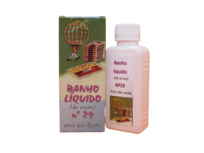 Frasco de banho líquido com caixa, etiqueta com texto em português sobre ervas e sorte.