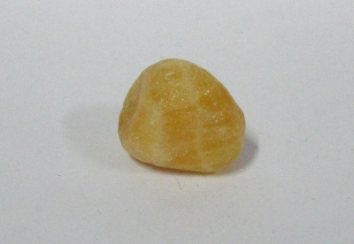 Pedra polida amarelo claro com textura lisa e formato irregular