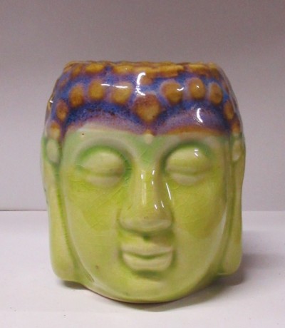 Vaso cerâmico verde em forma de cabeça de Buda com detalhes azuis e castanhos