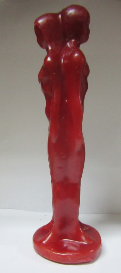 Escultura vermelha de duas figuras humanas femininas unidas pelas costas com acabamento brilhante