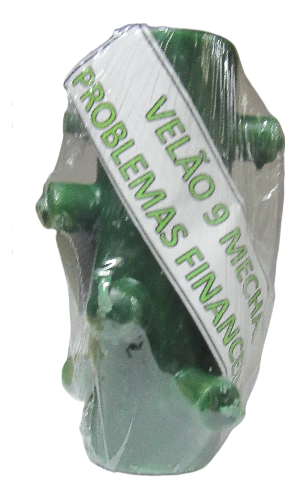 Vela verde de nove mechas em saco plástico com etiqueta escrita 'VELÃO 9 MECHAS PROBLEMAS FINANCI'