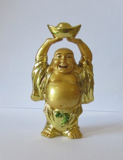 Estátua dourada de Buda sorridente segurando objeto acima da cabeça