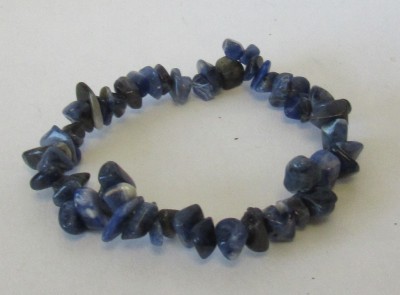 Pulseira azul com pedras irregulares sobre superfície branca