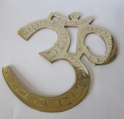 Símbolo Om dourado em metal com gravações sobre fundo branco