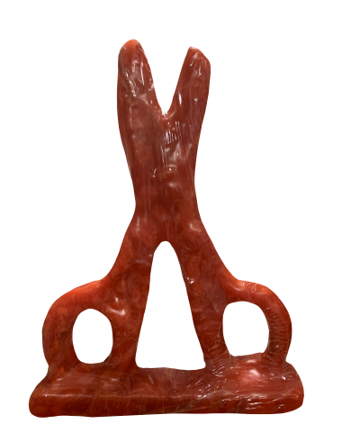 Escultura abstrata vermelha em forma de X com aberturas circulares e triangular