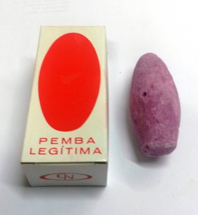 Pedra pomes roxa ao lado de caixa branca com oval vermelho e texto PEMBA LEGÍTIMA