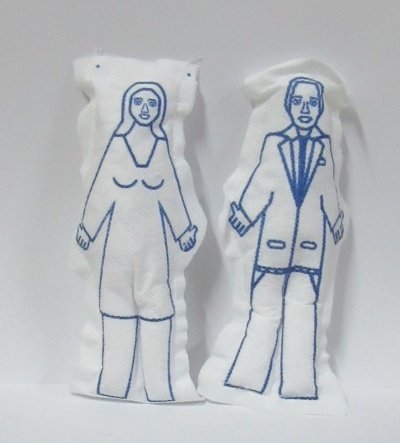 Dois bonecos de pano brancos com desenhos azuis de homem e mulher