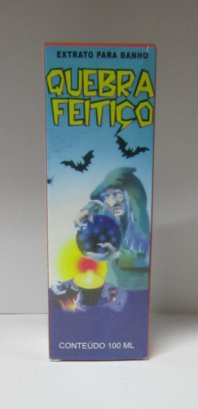 Embalagem azul de extrato para banho chamada Quebra Feitiço com ilustração de pessoa com capuz e bola de cristal, morcegos e vela acesa.