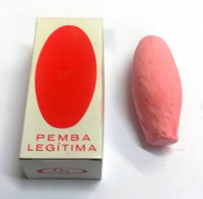 Caixa branca com oval vermelho e texto 'PEMBA LEGÍTIMA' com objeto rosado ao lado