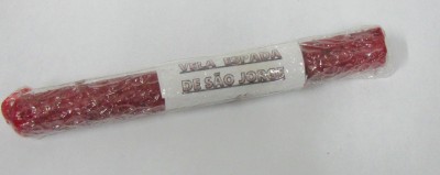 Enchido vermelho embalado em plástico transparente com rótulo branco e texto 'VELA PAGÃ DE SÃO JORGE'