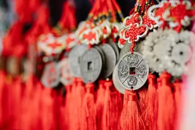 Moedas decorativas chinesas penduradas em cordões vermelhos com nós e franjas