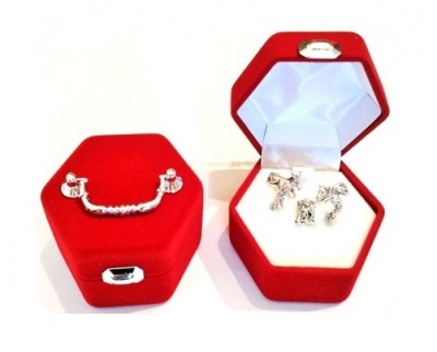 Caixas de veludo vermelho com joias prateadas no interior acolchoado branco