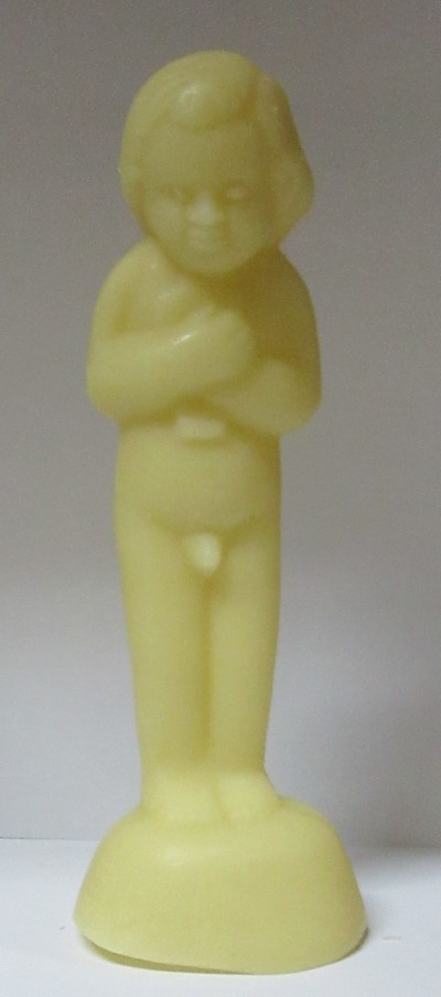 Escultura amarela de figura infantil em pé sobre base arredondada