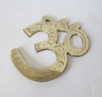 Figura decorativa dourada em formato do símbolo Om sobre fundo branco