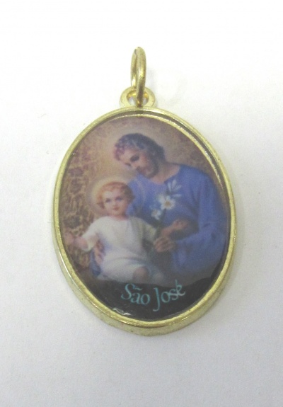 Medalha dourada oval com imagem religiosa de São José e Menino Jesus