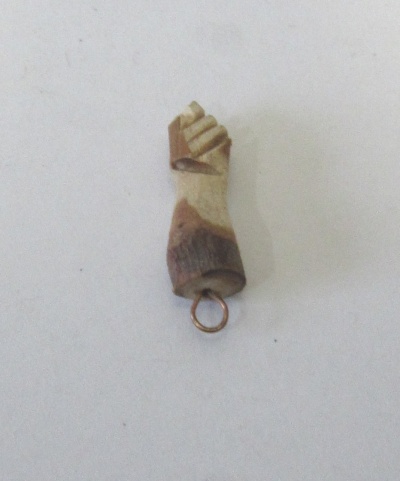 Pingente de madeira em forma de mão fechada com anilha metálica