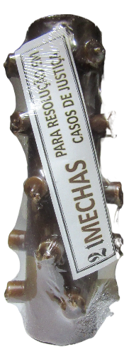 Vela decorativa branca com nós e etiqueta com texto em espanhol.