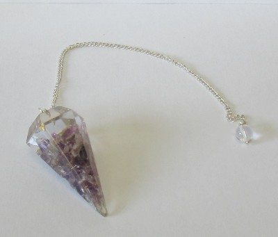 Pêndulo de cristal multifacetado com corrente prateada sobre fundo branco