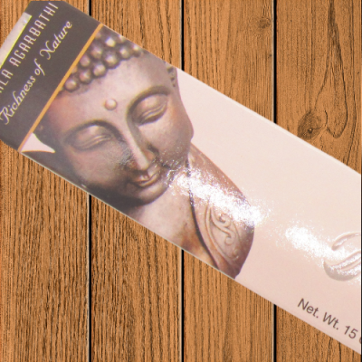 Caixa de incenso com imagem de Buda e texto em branco sobre fundo de madeira