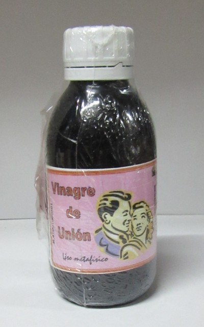 Frasco preto com tampa branca e rótulo rosa de Vinagre de Unión com imagem de casal