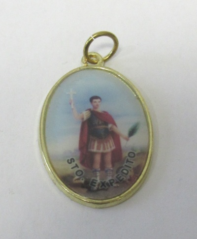 Medalha oval dourada com imagem de soldado romano e texto STO EXPEDITO