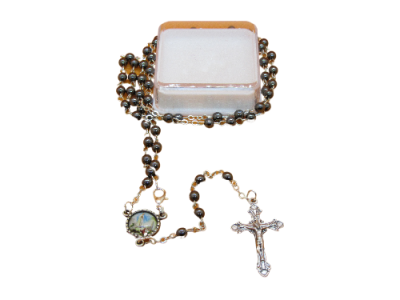 Terço com contas castanhas, medalha colorida e crucifixo prateado sobre caixa transparente