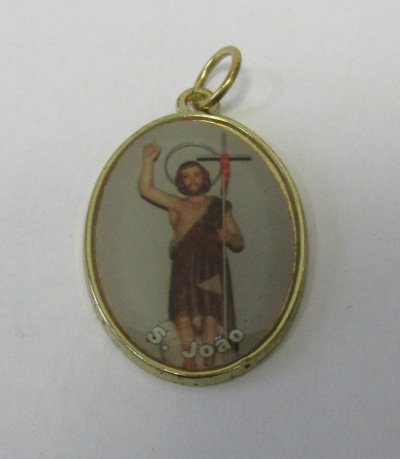 Medalha oval dourada com imagem de São João e texto S. João