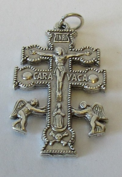 Pendente metálico em forma de cruz com detalhes religiosos e texto INRI e CARA VACA.