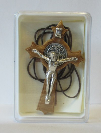 Crucifixo de madeira com figura metálica de Cristo numa caixa plástica transparente.
