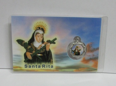 Cartão com imagem de Santa Rita e medalhão metálico com a mesma imagem, fundo de céu colorido.