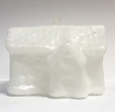 Vela branca em formato de casa com telhado texturizado e porta