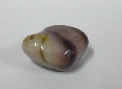 Pedra polida irregular com tons creme, castanho claro e roxo sobre fundo branco