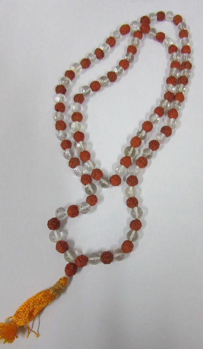 Colar de contas transparentes e marrons com pendente amarelo em fundo branco