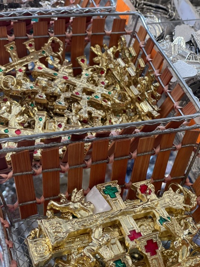 Caixa com crucifixos dourados com detalhes vermelhos e verdes