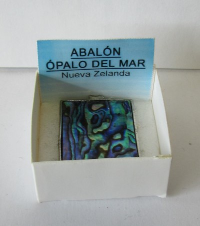 Objeto quadrado com padrão iridescente em caixa branca e cartão azul com texto