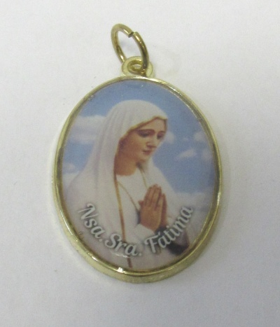 Medalha oval dourada com Nossa Senhora de Fátima e texto
