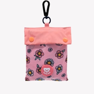 Bolsa pequena rosa com padrão floral, botão laranja, fecho superior e clipe preto