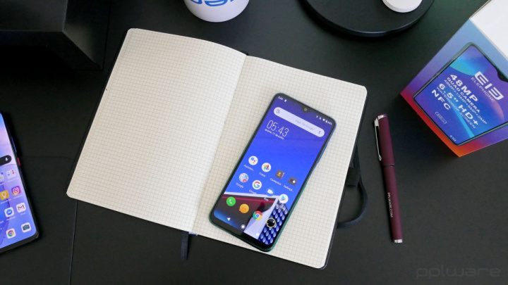 Preço, bateria e processador são o mais importante na compra de um smartphone Telemóvel sobre caderno aberto com caneta e caixa na mesa