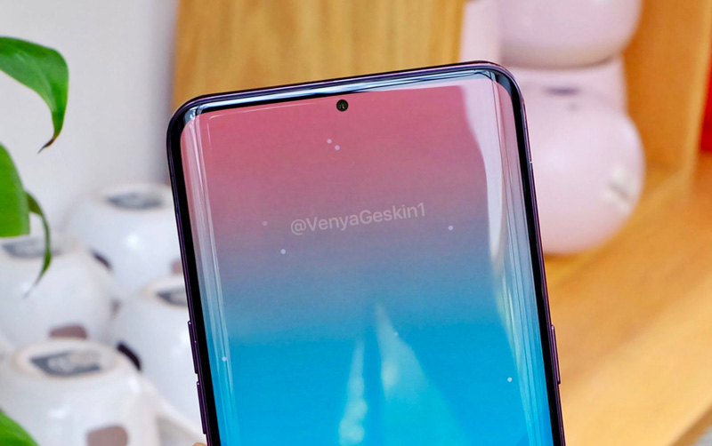 Samsung Galaxy S10: Está preparado? Smartphone com ecrã curvo a azul e preto, prateleira de madeira e vasos brancos ao fundo